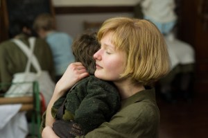 Young Philomena (Sophie Kennedy Clark) holding her son tightly in the sole hour a day that she is given free time at the nunnery.