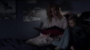 Amelia reading Sam a book to help him go to sleep. Only, without realising it, she is reading to him the poetry book written by the Babadook.