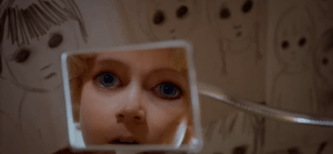 Margaret, who by this point has drawn so many pictures with abnormally big eyes that she is beginning to them (maddeningly) in her own reflection.