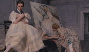 Einar holding a dress as his wife, Gerda (Alicia Vikander), draws him as a woman. Holding the dress, however, awakens Lili.