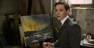 Einar Wegener (Eddie Redmayne), before his transformation, painting a view of his small hometown area.