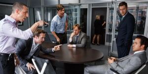 Mark Baum (Steve Carrell, sitting down in the centre), contemplating the horror about to unravel, as his associates shout at Jared Vallett (Ryan Gosling, sitting down, right).