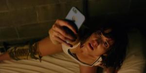 Michelle (Mary Elizabeth Winstead) looking for reception upon waking up to find herself locked in a bunker with her leg in a brace.